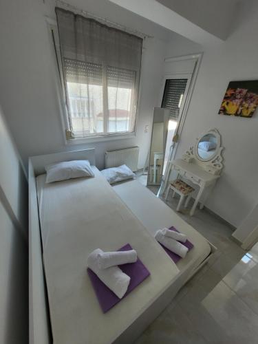 1 Schlafzimmer mit einem großen weißen Bett und 2 Handtüchern in der Unterkunft Ina's Masionette in Nea Iraklitsa