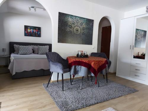 a living room with a table and a bed at Sonniges Appartement am Tegernsee in Gmund am Tegernsee