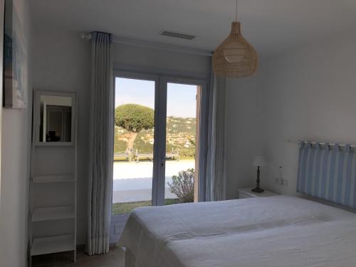 a bedroom with a bed and a large window at Villa "La vie est belle...!" in Cavalaire-sur-Mer