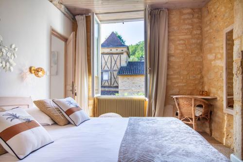 1 dormitorio con cama y ventana grande en Le Clos Vallis, en Sarlat-la-Canéda