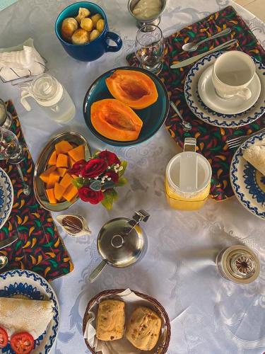 a white table with plates of food on it at Pousada Carvalhos - Camaçari in Camaçari