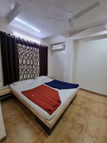 a bedroom with a bed with a red and blue blanket at Sai Anand in Nashik
