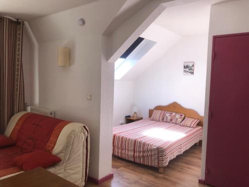 a bedroom with a bed and a couch in a room at T1 bis A CAUTERETS - 4 VOYAGEURS in Cauterets