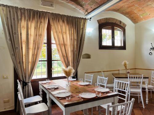 een eetkamer met een houten tafel en witte stoelen bij Agriturismo Sabidor in Malalbergo