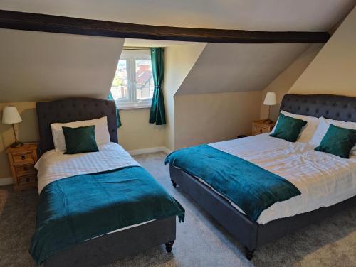 1 dormitorio con 2 camas y ventana en The Halt, Sheringham - 2x car spaces, Family friendly holiday home close to beach, en Sheringham