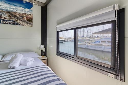 1 dormitorio con ventana y vistas al puerto deportivo en Houseboat Sardinia Suite, en Cagliari