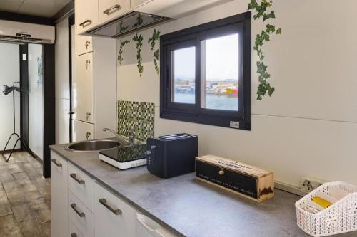 cocina con encimera con fregadero y ventana en Houseboat Sardinia Suite, en Cagliari