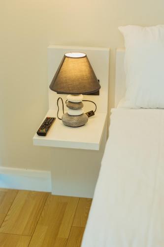 a bedside table with a lamp and a remote control at Batumi River Source in Batumi