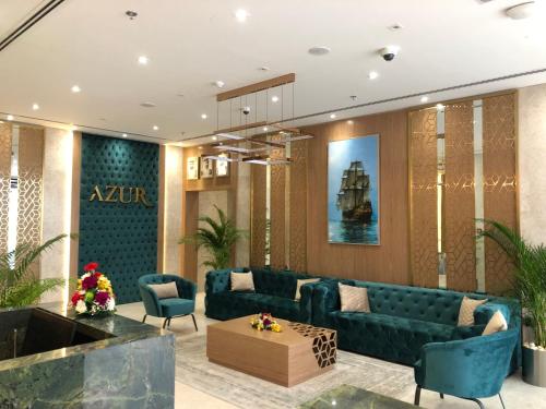a living room with a blue couch and chairs at Azur Regency Hotel Apartments in Dubai