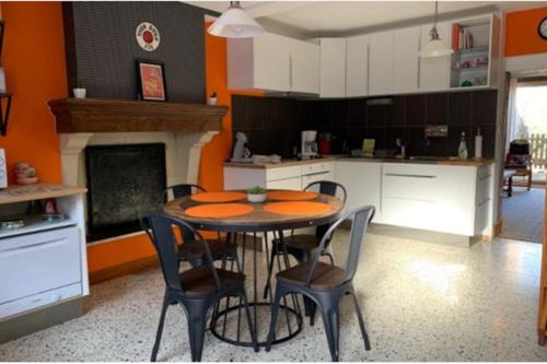 une cuisine avec une table et des chaises dans une pièce dans l'établissement Gîte du Vallon-Les Roches., à Les Hautes-Rivières
