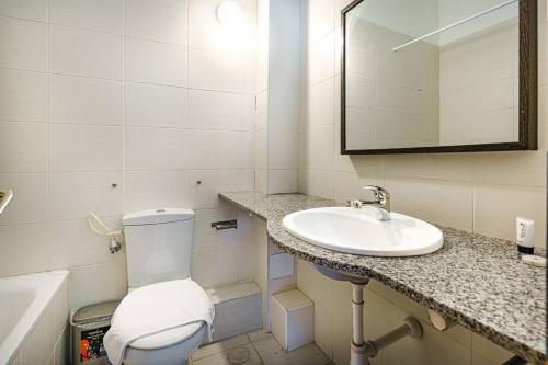 La salle de bains est pourvue de toilettes, d'un lavabo et d'un miroir. dans l'établissement Flea Market 1BR - 6 09 Tankhum St Tel Aviv #, à Tel Aviv