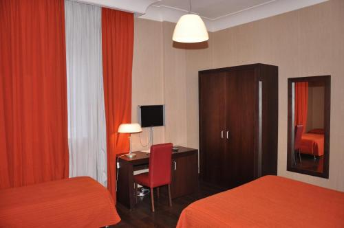 a hotel room with two beds and a desk with a chair at Hotel Fontana Del Re in Ariano Irpino