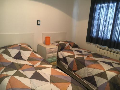 1 dormitorio con 2 camas junto a una ventana en Rio Negro Loft en Viedma