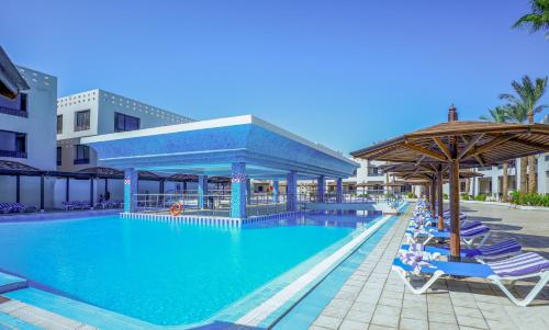 Blend Club Aqua Resort في الغردقة: مسبح كبير مع كراسي ومظلات