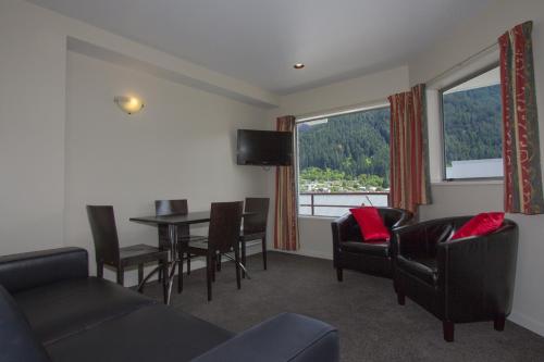a living room with a couch and a table and chairs at Caples Court Motel & Apartments in Queenstown