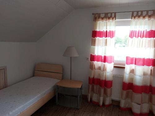 Habitación pequeña con cama y ventana en FeWo Stauber, en Amtzell