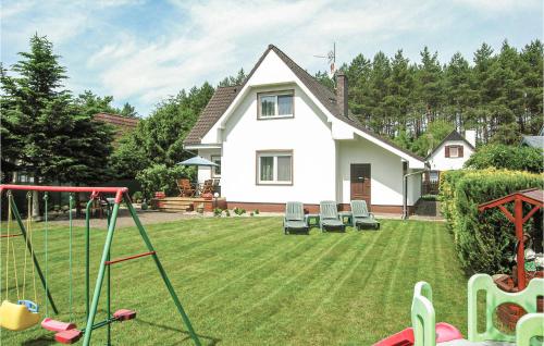 una casa con un cortile con sedie e un'altalena di 3 Bedroom Gorgeous Home In Santoczno a Santoczno