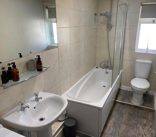 a bathroom with a sink and a tub and a toilet at HenreeenOnWidewater in Lancing