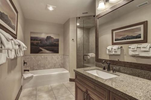 a bathroom with a tub and a sink and a bath tub at Crystal Peak Lodge 4 Bedroom Ski In, Ski Out Slopeside Condo At The Base Of Peak 7 in Breckenridge