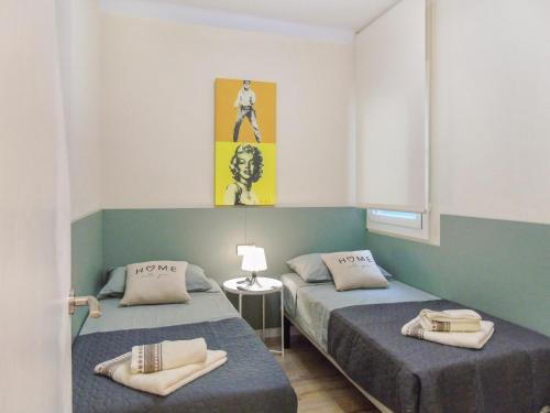 布拉內斯的住宿－CozyCatalonia - Comfortable Apartment in Central Blanes，一间设有两张床的客房,墙上挂着一张照片