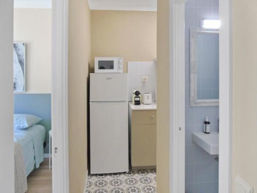 a small kitchen with a refrigerator and a sink at CozyCatalonia - Comfortable Apartment in Central Blanes in Blanes