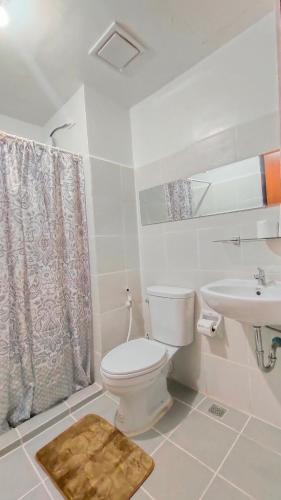 a bathroom with a toilet and a sink at The URBANSTAY Bacolod City in Bacolod