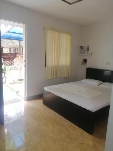 a bedroom with a bed and a sliding glass door at Dubay Panglao Beachfront Resort in Panglao Island