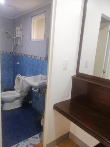 ein Badezimmer mit einem WC, einem Waschbecken und einem Spiegel in der Unterkunft Dubay Panglao Beachfront Resort in Panglao