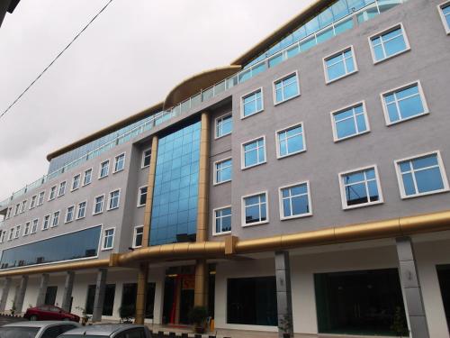 ein großes Gebäude mit Glasfenstern auf einer Straße in der Unterkunft Supreme Hotel in Malakka