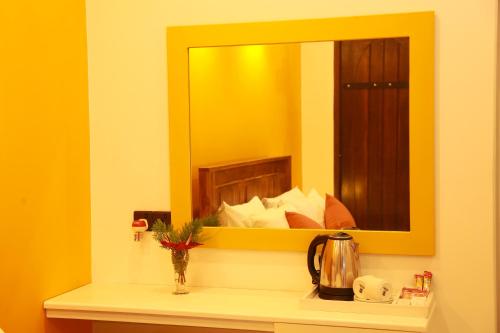 a mirror on a wall above a counter in a room at Ali Weta Safari Resort in Udawalawe