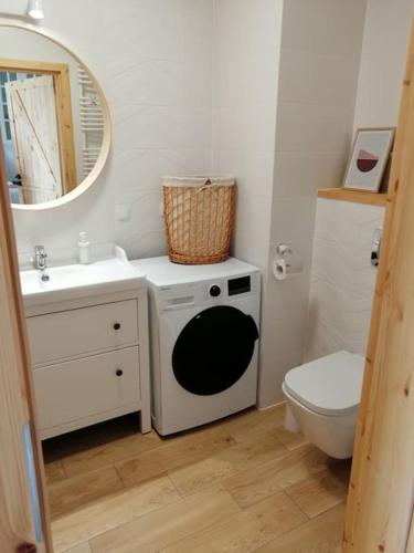 La salle de bains est pourvue d'un lavabo, de toilettes et d'un miroir. dans l'établissement Boho apartament - studio, à Kołobrzeg