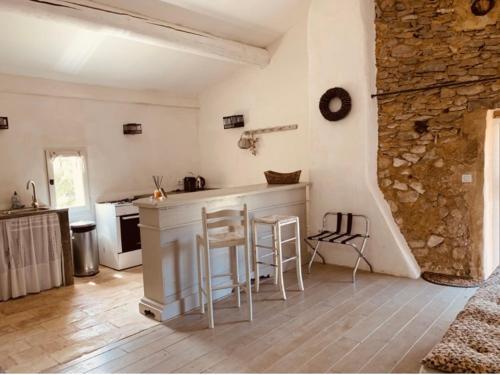 een keuken met een aanrecht en krukken in een kamer bij Le Vieux Portail in Saint-Saturnin-dʼApt