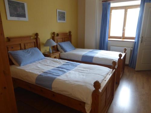 two beds in a bedroom with a window at L'Hirondelle Chambres d'Hotes in Saint-Mathieu