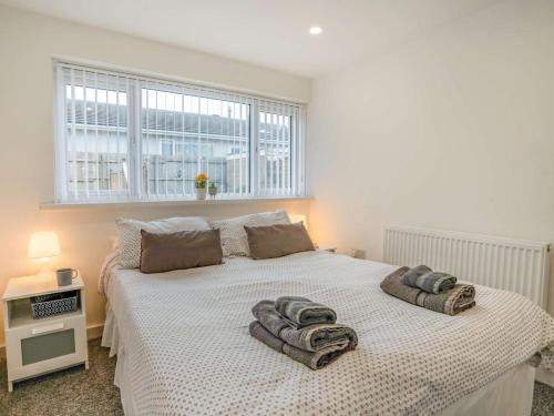 a bedroom with a bed with towels on it at 3-Bed 5-6 berth modernised bungalow! in Tenby