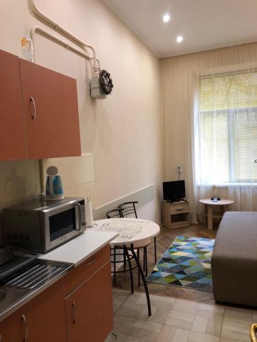 a kitchen with a microwave and a table at Apartament at Park in Lviv