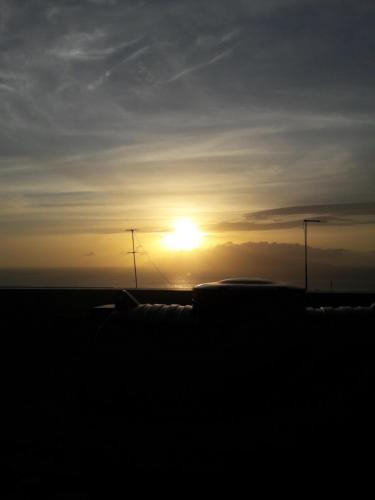 a sunset with the sun setting in the distance at Casa Alegre in São Filipe