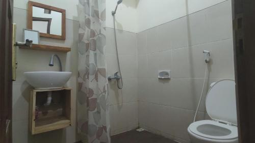 a bathroom with a toilet and a sink at Choko Homestay in Tjolomadu