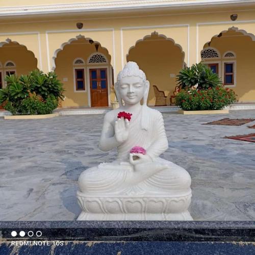a white statue of a woman holding a flower at Fort Chabariya in Kekri