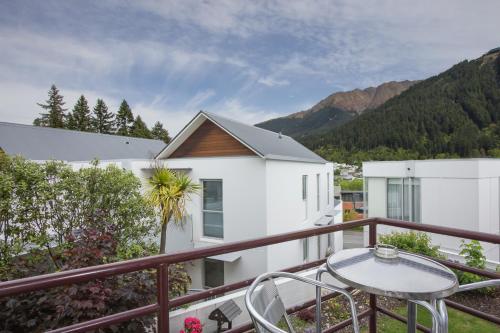 a balcony with a table and chairs and mountains at Caples Court Motel & Apartments in Queenstown