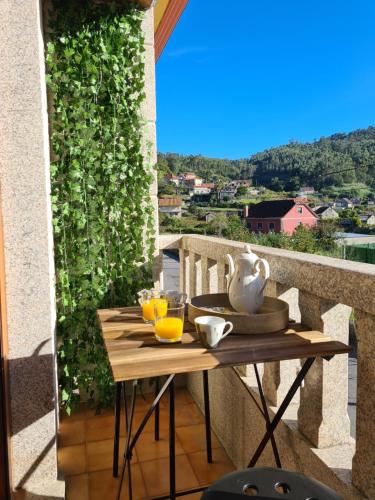 una mesa con una jarra y gafas en el balcón en A Veiga Grande, en Pontevedra