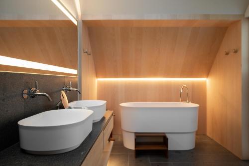 a bathroom with two sinks and two toilets at Miramonti Boutique Hotel in Avelengo
