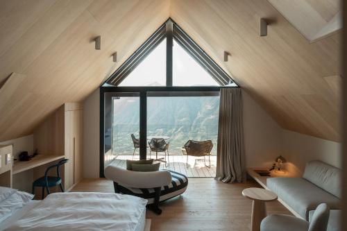 a bedroom with a large window in a attic at Miramonti Boutique Hotel in Avelengo