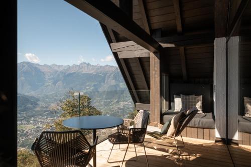 a balcony with a table and chairs and mountains at Miramonti Boutique Hotel in Avelengo