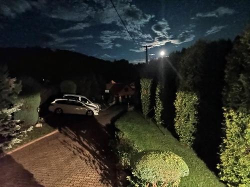a white car parked on a road at night at Dom Sosenek in Kluszkowce