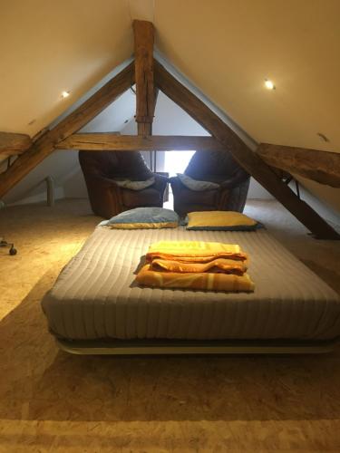 a large bed in a attic with a mattress at Petite maison de campagne in Recey-sur-Ource