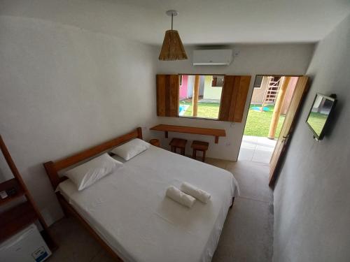 Pousada Ventos e Velas في بورتو دي بيدراس: غرفة نوم عليها سرير وفوط