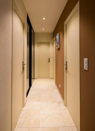 a corridor of a hallway with doors and a tile floor at JADO House in Dakar