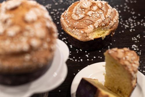 twee muffins en een stuk taart op een tafel bij Bad Ratzes in Siusi