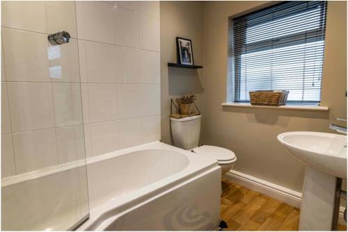 uma casa de banho com uma banheira, um WC e um lavatório. em Carrington 3 Bedroom Home, FREE PARKING and Close to the City Centre em Nottingham
