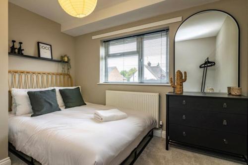 um quarto com uma cama com um espelho e uma cómoda em Carrington 3 Bedroom Home, FREE PARKING and Close to the City Centre em Nottingham